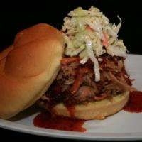 PULLED PORK SANDWICH · Topped with Carolina BBQ sauce, and coleslaw
