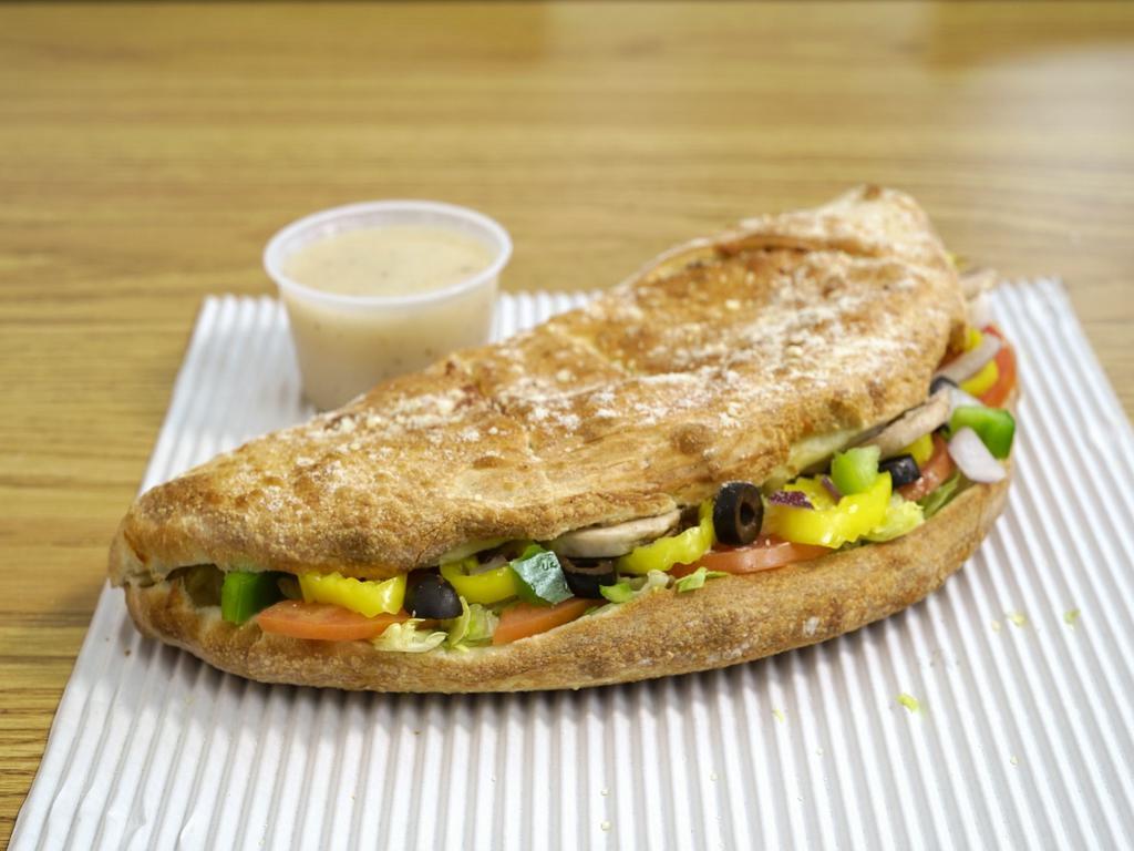 Veggie Calzone · Mushroom, green peppers, mild peppers, black olives, onions,lettuce,tomatoes, side italian dressing and cheese.