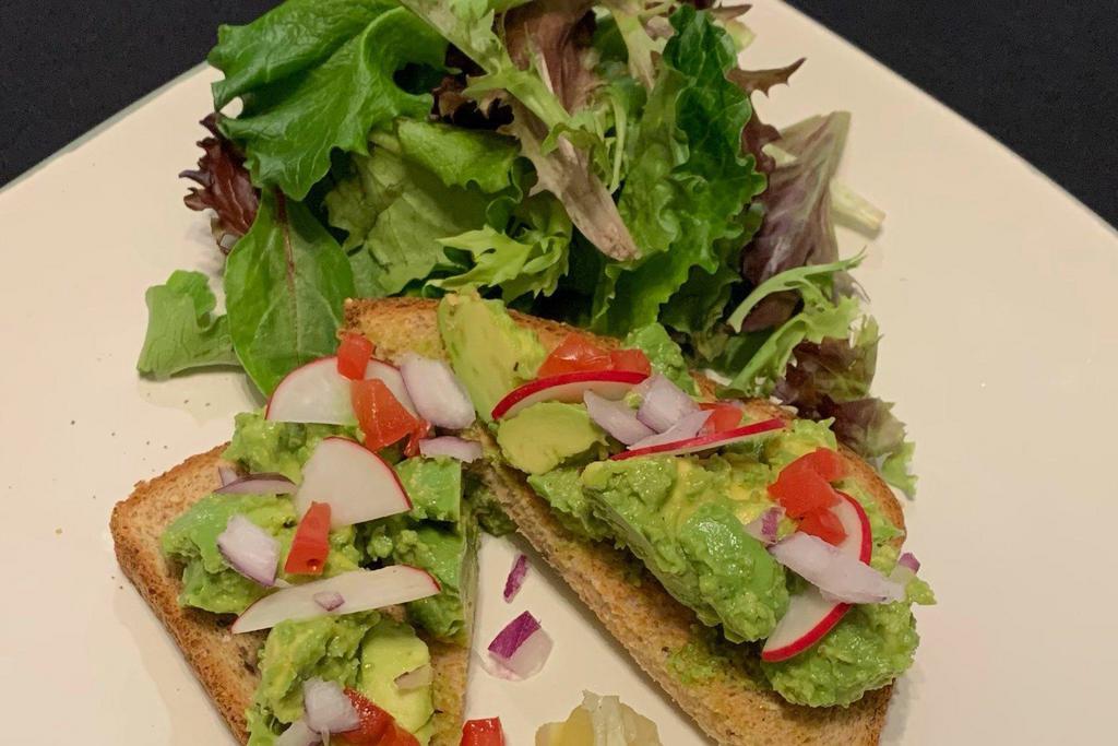 Avocado Toast · Smashed Avocado on Multigrain Bread Topped with Sea Salt, Preserved Lemon and Herb Oil. Served with Radish and Pico on the Side.