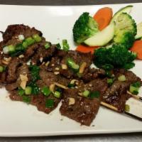 Grilled Lemongrass Beef · Marinated Angus sirloin flap beef topped with lemongrass, and options steam vegetables and r...