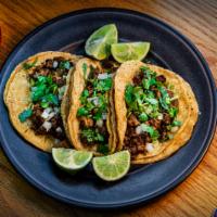 Smoked Brisket Taco · Corn or flour tortilla, smoked beef brisket, cilantro, onions, lime, and choice of red or gr...