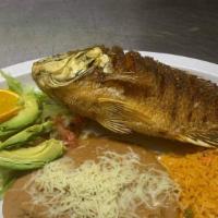 Mojarra Frita · Deep fried tilapia fish plate, rice beans and salad.