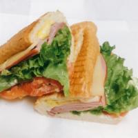 Hot Ham and Cheese Sandwich · Freshly sliced ham, Swiss cheese with tomatoes, lettuce, mustard and mayo on a baguette.