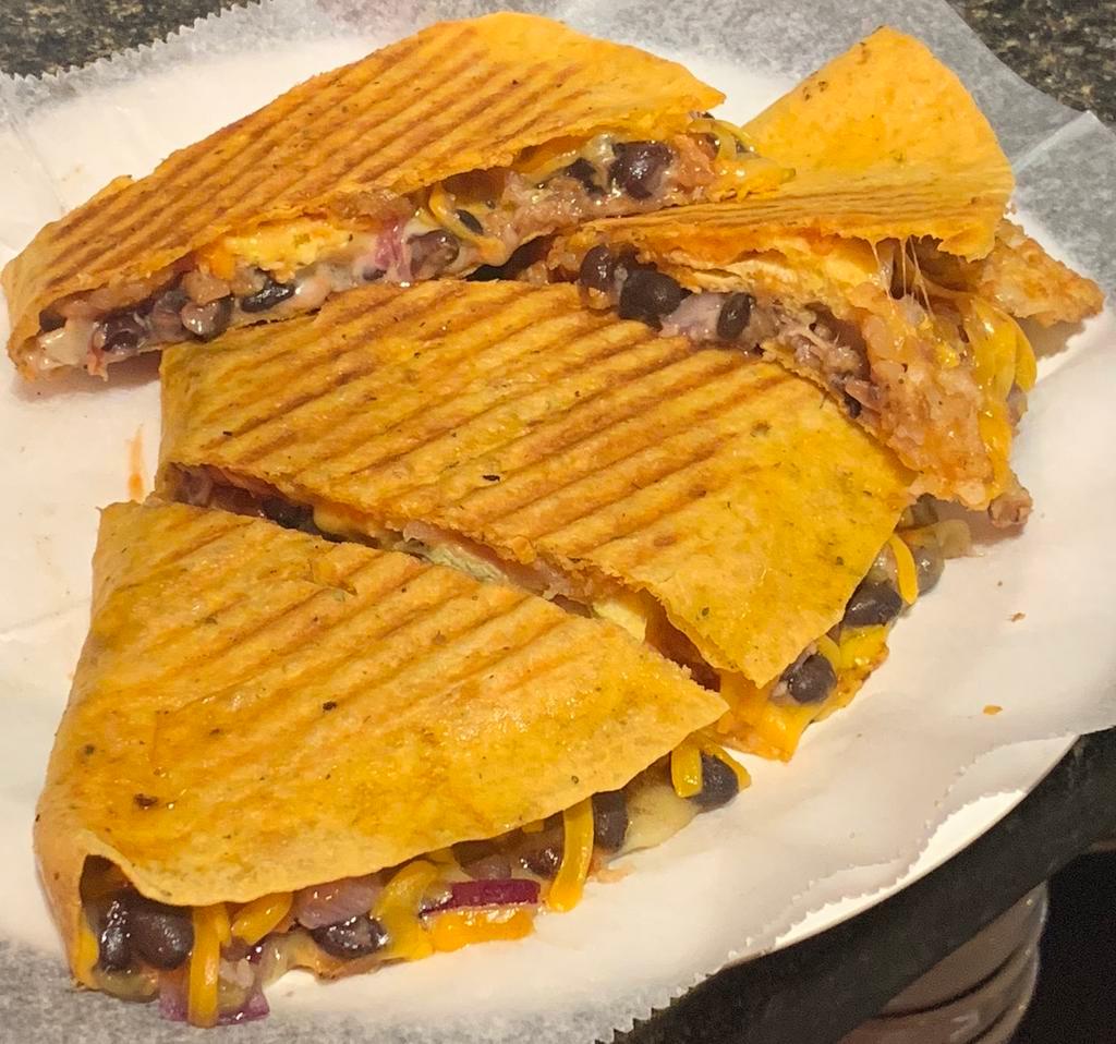 Seattle Center Breakfast Quesadilla · Tortilla filled with eggs, onions, potatoes, black beans with chilies, sausage, bacon, pepper jack and cheddar cheese.Grilled and served with salsa cream cheese.