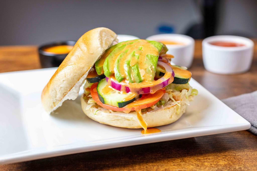 Avocado Veg Out Bagel Sandwich · Lettuce, tomato, cucumber, red onion, avocado, cream cheese finished with a drizzle of honey blaze on toasted plain bagel.