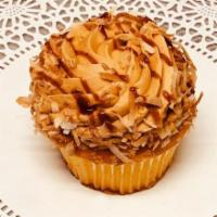 Dulce de Leche Cupcake · Vanilla cupcake filled with chocolate ganache topped with dulce de leche frosting drizzed wi...