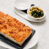 Cheese-Baked Focaccia · Housemade focaccia topped with mozzarella and fontina cheese that have been tossed with mama...