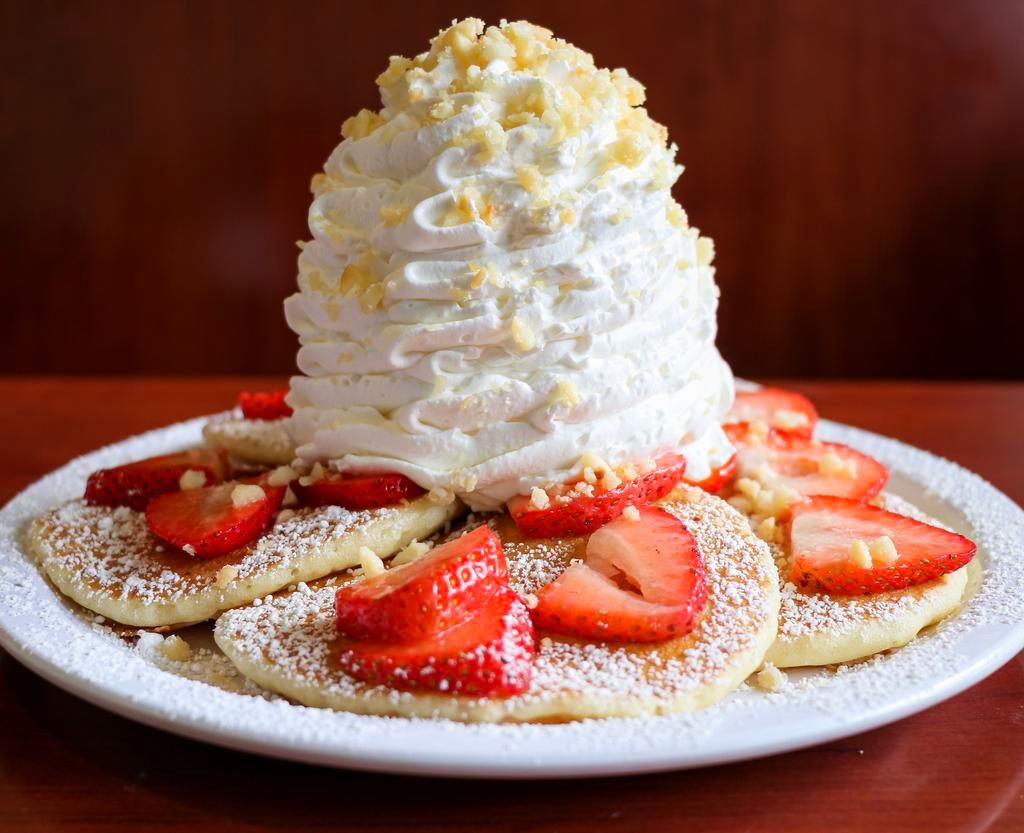 Fresh Strawberry Whipped Cream Pancakes · Five Fluffy Buttermilk Pancakes topped with fresh strawberries whip cream and macadamia nuts