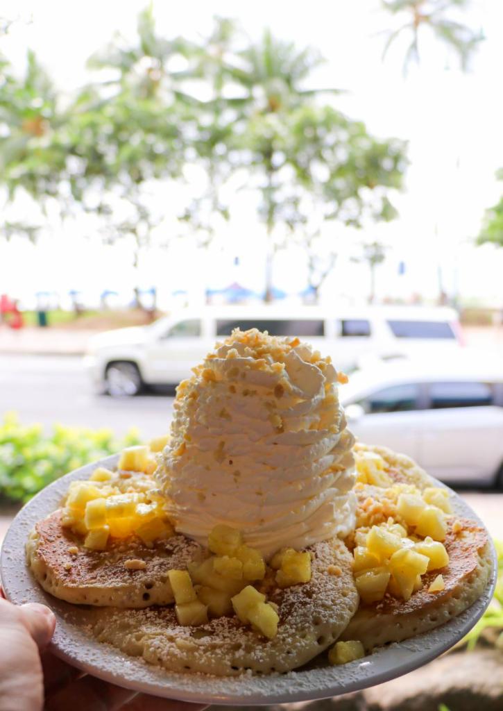 Fresh Pineapple Whipped Cream Pancakes · Five Fluffy Buttermilk Pancakes topped with fresh Pineapple whip cream and macadamia nuts