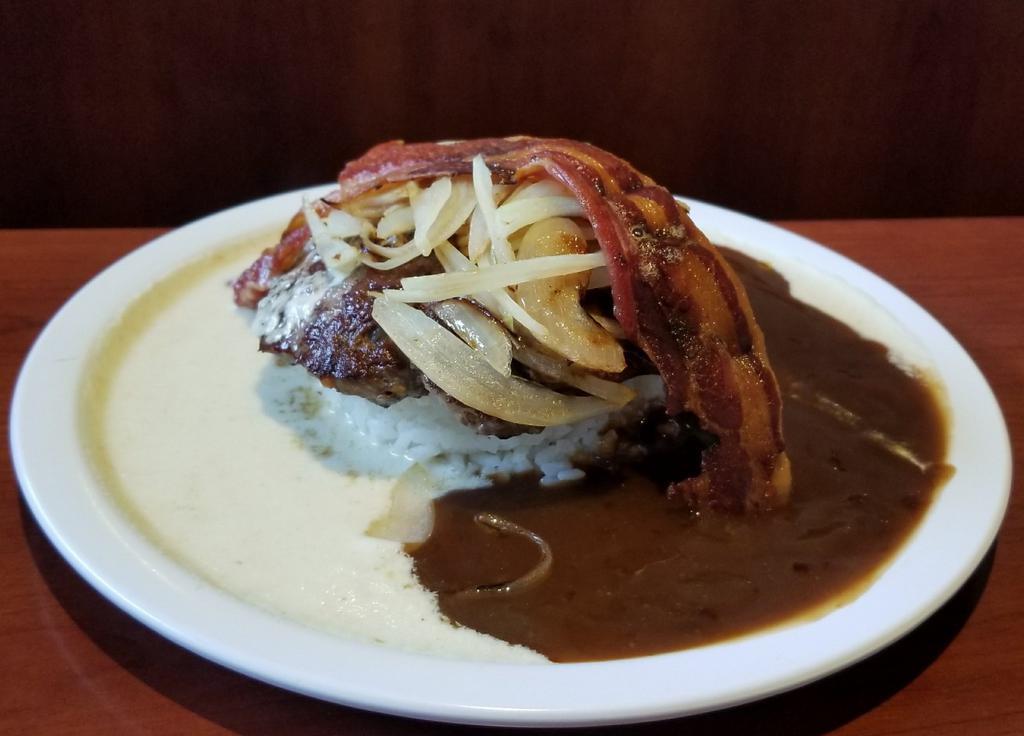 Hapa Hamburger Steak · A 100% local beef patty over rice, topped with both country and brown gravy, sautéed white onions, with one crispy strip of bacon on top