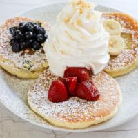 Whipped Cream Pancake Sampler · 3pcs strawberry, banana and blueberry topped with whipped cream and a sprinkle of macadamia ...