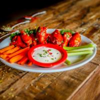 Spicy Chicken Wings · Chicken wings tossed in Buffalo wing hot sauce and  garlic butter. Served with celery, carro...