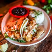 Baja Fish Tacos · 2 soft flour tortillas filled with plump beer battered white fish, cabbage, pico de gallo, p...