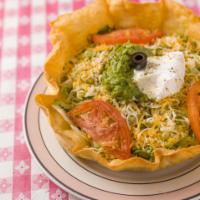 #5. Tostada Salad · Cream and guacamole layered in a crisp tortilla shell, topped with an herb dressing. Add shr...