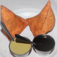 Traditional Samosas · Classic spiced potatoes and green peas inside a flaky crust. Served with tamarind and green ...