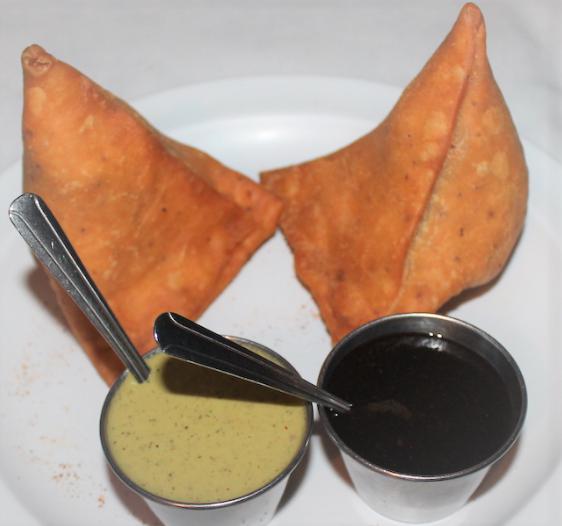 Traditional Samosas · Classic spiced potatoes and green peas inside a flaky crust. Served with tamarind and green chutneys.