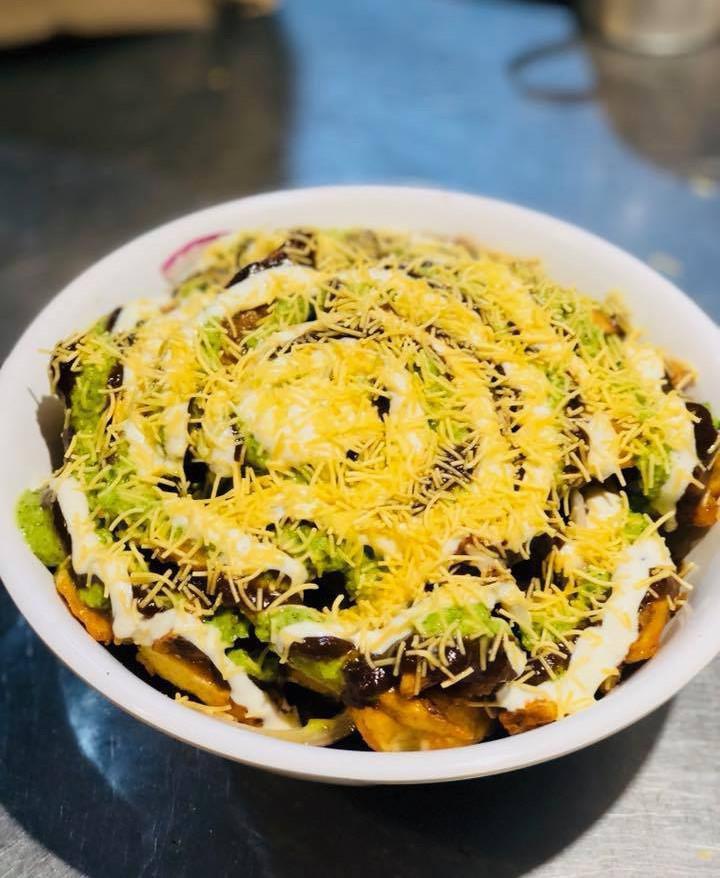 French Fries Chaat · Spiced fries mixed with red onion, crispy chickpeas and cilantro. Topped with chutneys and tart yogurt.