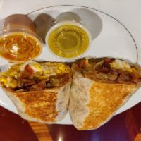 Classic Breakfast Burrito · Eggs, hash browns, beans, cheese, sour cream and bacon with a side of hot sauce.