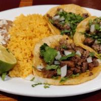 Steak Taco Dinner · Three tacos served with rice and beans. Tortilla shell containing cilantro and onions
