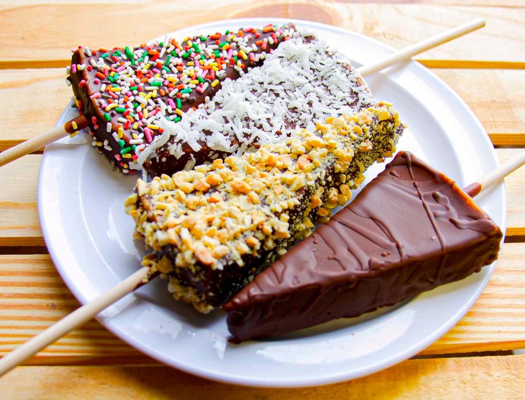 Cheesecake Dippers · Cheesecake dipped in chocolate and topping of your choice: plain, coconut, peanuts, or sprinkles.
