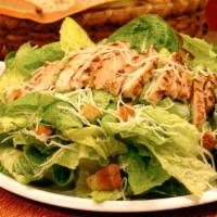 Chicken Caesar Salad · Romaine hearts, Parmesan cheese and croutons tossed with grilled chicken and Caesar dressing.