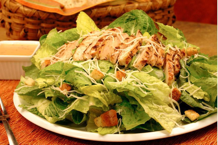 Chicken Caesar Salad · Romaine hearts, Parmesan cheese and croutons tossed with grilled chicken and Caesar dressing.