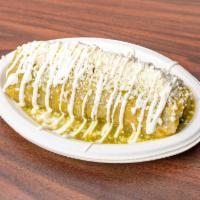 Wet Burritos · A burrito covered in green salsa, topped with sour cream and queso fresco.