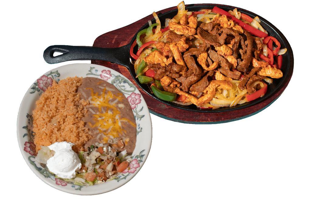 Chicken & Steak Combo Fajita · Chicken and Steak, grilled with fresh bell peppers, onions, and spices. Served with refried beans, rice, fresh tortillas, sour cream, and Pico de Gallo.