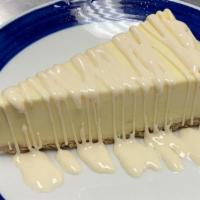 vanilla topping over cheesecake · New York style cheesecake on top of a graham cracker crust. Served with vanilla topping.