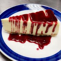 Raspberry topping over cheesecake · New York style cheesecake on top of a graham cracker crust. Served with raspberry topping.