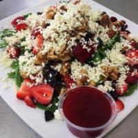 Spinach Salad · Spinach, walnuts, cranberries, strawberries, raisins and topped with feta and raspberry vina...