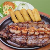 27. Churrasco a la Pureña con Camarones · Sirloin steak with shrimp on top, rice, salad and fried cassava.