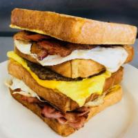 The Busti Sandwich · Quadruple Texas French toast sandwich with a layer of over medium egg and ham, layer of scra...