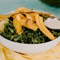 Kale Caesar · Curly kale topped, caesar dressing (on the side) and crunchy plantain chips.