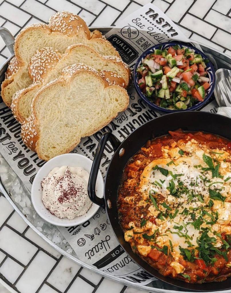 Shakshuka · Served with Challah bread, 2 poached egg in a Tunisian tomato & pepper sauce and side salad & tahini. Add feta for an additional charge.