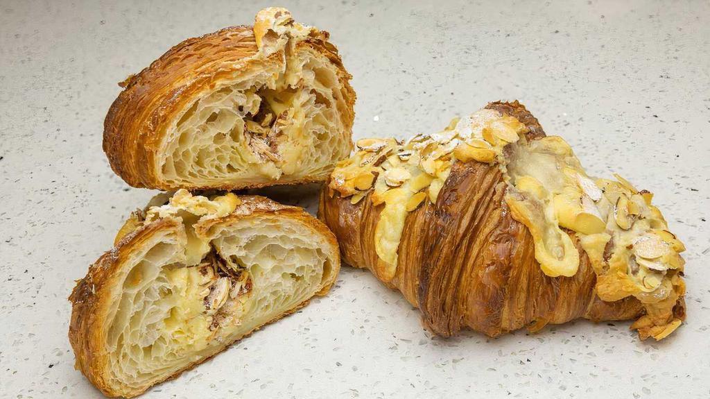 Almond Croissant · Twice baked butter croissant filled and topped with almond frangipane and sliced almonds.