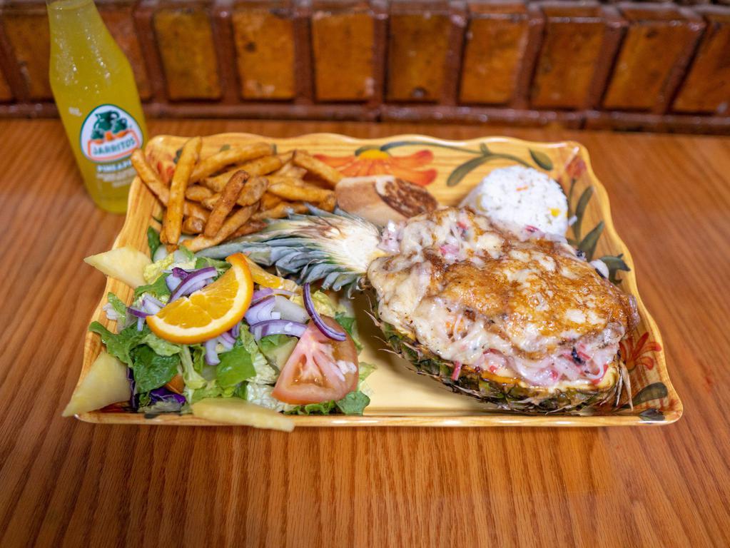 Piña Rellena · Stuffed pineapple with shrimp, scallops, octopus, imitation crab served with salad, rice, garlic bread and french fries.
