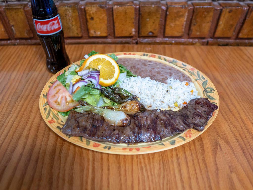 Carne Asada · Grilled inside skirt steak with onions, roasted chiles, white rice, beans, salad and tortillas.