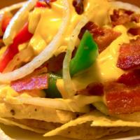 Super Cheesy Bacon Nachos · Nachos with bell peppers, onions, cheese, and bacon.