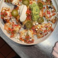 Temerario Nachos · Corn chips, avocado, beans chihuahua cheese,  crema pico de gallo, pickled jalapeños

