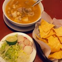 Pozole · Hominy soup with pork meat garnish with tostadas lime radishes and onions