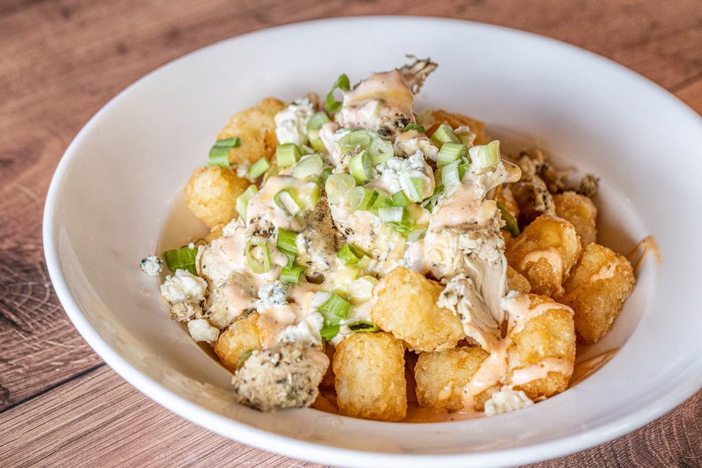 Buffalo Chicken Tots · Crispy tater tots topped with diced chicken, house-made creamy cheese sauce, green onions, blue cheese crumbles, and drizzled with buffalo ranch sauce