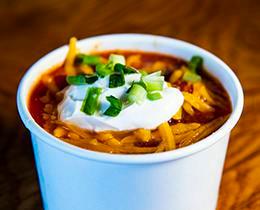 Chili · Beef chili with pinto and kidney beans. Garnished with cheddar cheese, sour cream and green onions