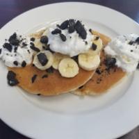 Oreo Pancakes  ( NEW) · Oreo pancakes topped with whipped cream and banana .