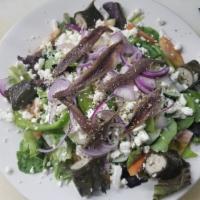 Greek Salad · Feta, olives, tomatoes, cucumbers, peppers, onions, lettuce, anchovies, grape leaves and ore...