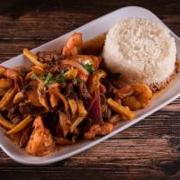 Saltado de Camarones · Traditional Peruvian stir-fry, with shrimps, red onions and tomatoes. Served with French fri...