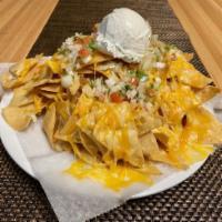 Cheesy Nachos · Crunchy tortilla chips covered with melted cheese topped with pico de gallo & sour cream.