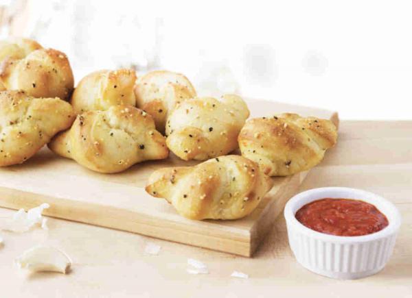 8 Pieces Garlic Knots · Introducing our new garlic knots made with fresh baked dough and garlic parmesan seasoning. Eight garlic knots are served with pizza sauce for dipping.