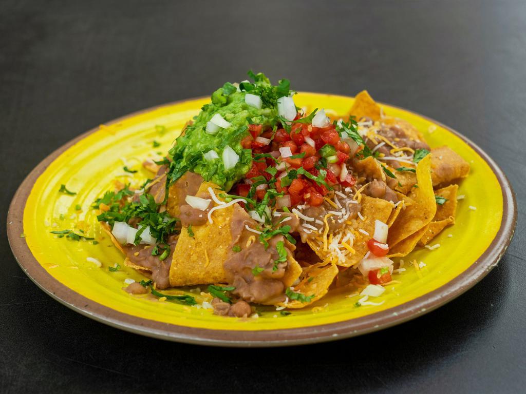Nachos with Meat · Your choice of meat. Topped with fresh guacamole, black or pinto beans, Jack or cheddar cheese, pico de gallo, and sour cream.