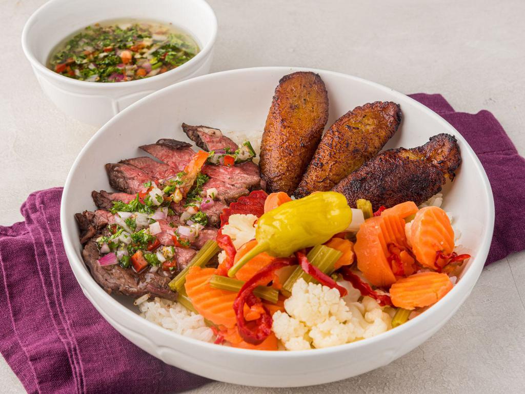 Parmesan pork bowl · Grilled pork sirloin topped with parmesan cheese and homemade chimichurri sauce served over rice, vinaigrette veggies and fried plantain.